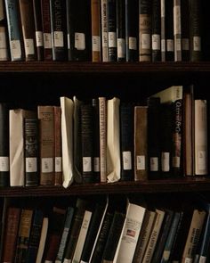 a book shelf filled with lots of books on top of wooden shelves next to each other