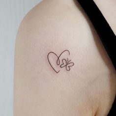 a woman's shoulder with a heart and two butterflies tattoo on the left side