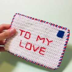 someone is holding up a piece of crocheted fabric with the words to my love written on it