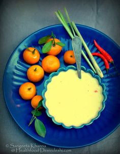 a blue plate topped with oranges next to chopsticks and an egg yogurt