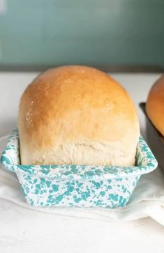 a loaf of bread sitting in a blue and white container next to another loaf of bread