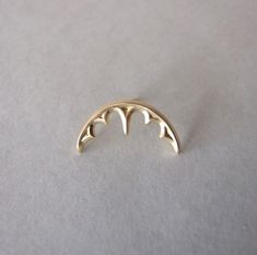 a gold plated metal ring with bats on it's sides, sitting on a white surface