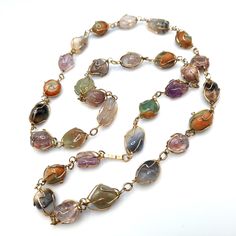 *Description: This is a beautiful gemstone wire wrapped vintage necklace from the 1960s to 1970s.  I tested the stones with the Presidium Gem Tester and each stone tested as a gemstone. Some of the stones include amethyst, jade, agate, and carnelian. The gold plated wire is wrapped around each gemstone in a very artistic manner. This would be a great necklace for your collection to wear for years to come. This would be a great addition to your vintage jewelry collection or make a great vintage gift! *Approximate Measurements: Length - 30 Inches, Weight - 2.2 Ounces *Condition: Very good vintage condition.  Will see signs of wear under magnification. See photos for details. *Hallmark:  Unsigned *Item # 6031 Please look at the photos carefully as they are a part of the description. We are mo Vintage Multicolor Gemstone Beads And Cabochons, Vintage Natural Gemstones, Vintage Gemstone Necklace For Healing, Vintage Healing Gemstone Necklace, Vintage Multicolor Agate Jewelry, Vintage Multicolor Wire Wrapped Jewelry, Vintage Multicolor Natural Gemstones, Vintage Agate Gemstone Beads, Vintage Crystal Necklaces For Jewelry Making With Natural Stones