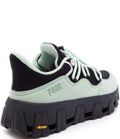 a green and black sneaker with the word p m b on it's side