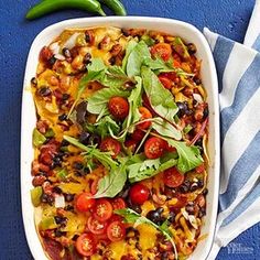 a casserole dish with tomatoes, black beans and spinach