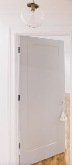 an open door in a white room with wood floors