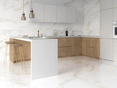 a modern kitchen with marble counter tops and white cabinets, along with bar stools