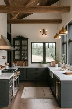 a large kitchen with black cabinets and white counter tops, gold accents on the ceiling