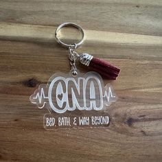 an acrylic keychain with a tassel hanging from it