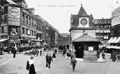 an old black and white photo of people walking in the street