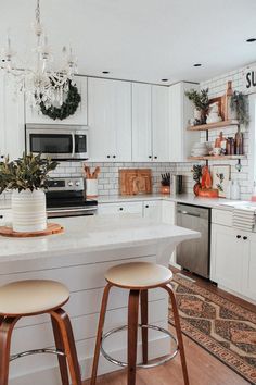 a kitchen with white cabinets and wooden stools