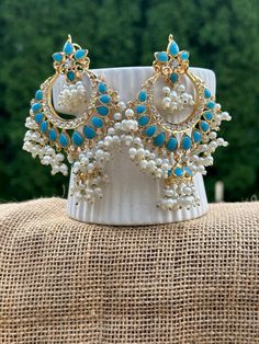 **Stunning Ethnic Blue and White Jhumka Earrings** Elevate your style with these exquisite ethnic jhumka earrings, beautifully handcrafted to add a touch of elegance and tradition to your wardrobe. These statement earrings feature a captivating combination of blue stones and white pearls, meticulously arranged to create a mesmerizing design that is perfect for any occasion. **Features - **Design Traditional Chandbali style with intricate detailing. - **Materials High-quality blue stones, white pearls, and gold-tone metal. - **Length Approximately 4 inches (as indicated by the ruler for scale). - **Handcrafted Each piece is carefully handcrafted to ensure superior quality and uniqueness. - **Versatile Suitable for weddings, festive occasions, parties, or as a statement piece with your every Turquoise Chandbali Earrings With Latkans, Turquoise Kundan Earrings For Festivals, Traditional Turquoise Danglers For Wedding, Bohemian Chandbali Jhumkas For Eid, Turquoise Kundan Chandbali Earrings, Festive Kundan Turquoise Earrings, Festive Turquoise Kundan Earrings, Turquoise Chandbali Earrings Bollywood Style, Turquoise Chandbali Bollywood Earrings