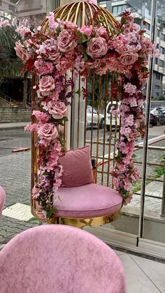 pink chairs and a birdcage decorated with flowers