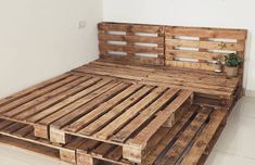 a bed made out of wooden pallets with no sheets or pillows on the headboard