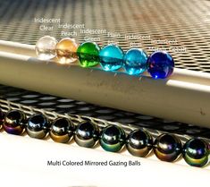 multicolored mirrored gazing balls are lined up in the sunlight