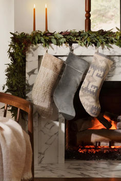 stockings hanging from a fireplace with candles in the background