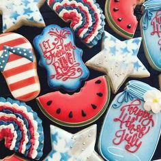 some decorated cookies are sitting on a table together with the words happy fourth of july