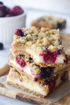 blueberry crumb bars stacked on top of each other with berries in the background