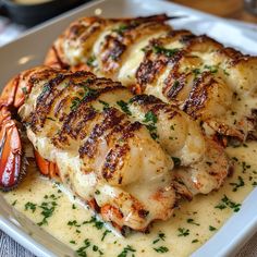 some chicken and lobsters are on a plate with gravy, garnished with parsley