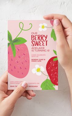 two hands holding up a pink and green strawberry birthday card with the words cup berry sweet on it