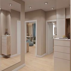 an empty living room and kitchen with large mirrors on the wall, in neutral colors