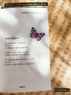 an open book with a butterfly on top of it and sheet music notes in the background