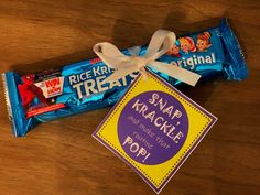 a wrapper and candy bar sitting on top of a wooden table next to a sign