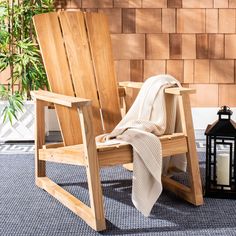 a wooden chair sitting on top of a blue rug next to a lamp and lantern