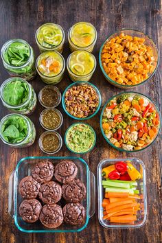 the meal is prepared and ready to be eaten on the wooden table, including carrots, celery, lettuce, cucumber, red peppers, black beans