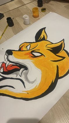 a drawing of a tiger's head on a piece of paper with paint and pencils