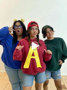 three girls in costumes posing for the camera with one pointing at the camera and wearing glasses