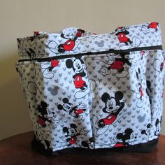 "This is a 8 pocket tote bag, with a deep inside with an inside pocket It measures 16\" wide X 13\" Tall. The colors are white wIth red and black Mickey print. It has a velcro closure. It is fully lined and has stabilizer in between to give it durability, the lining is black.. This is great as a Bingo Bag, a Diaper Bag, Craft Bag, Hair Accessory Bag, Knitting Bag, Nurse or Teacher Tote. Makes Great Gift, Mother's Day, Birthday Gift, Ready to ship." Red Double Handle Bag With Pockets, Large White School Bag, White Everyday Bags With Side Pockets, Everyday White Bags With Side Pockets, White Large Capacity Tote Diaper Bag, White Bags With Multiple Pockets For Daily Use, White Bag With Multiple Pockets For Daily Use, White Bag With Multiple Pockets For Everyday Use, White Tote Bag With Zipper Pocket