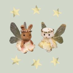 two small figurines are sitting next to each other in the shape of stars