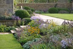 a garden with lots of different types of flowers and plants in it's center