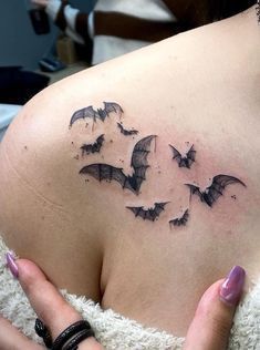 a woman's shoulder with bats on it