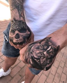 two people holding hands with tattoos on their arms and one has a dog's face painted on it