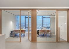 an open room with glass walls and sliding doors leading to a dining area that overlooks the city