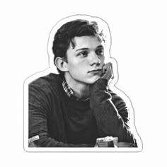 a black and white photo of a person sitting at a table with his hand on his chin