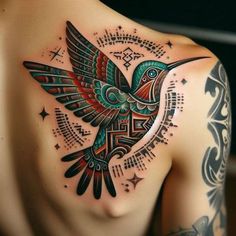 a colorful bird tattoo on the back of a man's shoulder and chest is shown