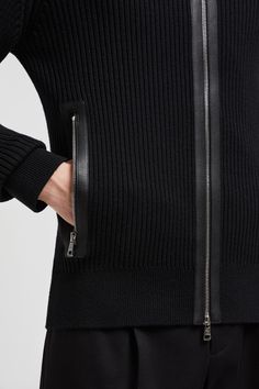 Crafted from ultrafine wool, this high neck cardigan is characterized by a timeless rib knit. The zip-up design boasts one of the season's style signatures: a supple leather trim along the zippers. Luxury Black Sweater With Ribbed Collar, Fitted Wool Ribbed Outerwear, Classic Merino Wool Ribbed Outerwear, Ribbed Merino Wool Outerwear For Work, Classic Black Ribbed Outerwear, Classic Ribbed Turtleneck Outerwear, Luxury Fitted Sweater With Ribbed Cuffs, Classic Winter Cardigan With Zipper Closure, Luxury Cardigan With Ribbed Cuffs