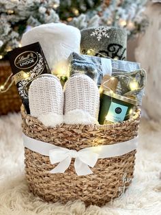 a basket filled with lots of items on top of a white rug next to a christmas tree