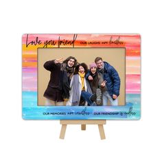 three people are posing in front of an easel with the words love you and laugh on it