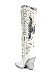 Add some glam to your cowboy boots! The Upbeat Western Boot In White is made from a faux leather fabrication and features rhinestone gems in varying sizes, a metallic, rounded collar, a knee-high shaft, Western-inspired patch and stitch detailing, a pointed toe silhouette, a chunky heel, and an inner ankle zipper closure. Feel like a star at any music festival or concert! Faux leather upper Pointed toe Chunky heel 21” shaft height 14" calf circumference 4.25” heel height Western Inspired Outfits, Wardrobe List, Wedding Cowboy Boots, White Boots Outfit, Black Western Boots, Fold Over Boots, White Cowboy Boots, Bota Country, Rodeo Outfits