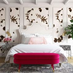 a white bed sitting in a bedroom next to a potted plant on top of a table