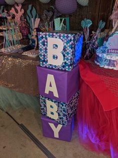 baby blocks are stacked on top of each other in front of a table with decorations