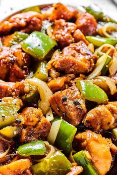 stir fry with chicken, peppers and onions in a skillet on a white plate