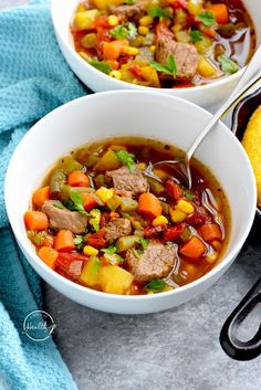 two bowls of soup with meat, vegetables and corn on the side next to bread