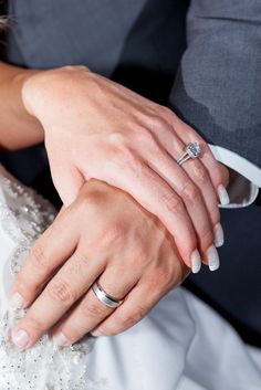 the bride and groom are holding each other's wedding rings on their hands,