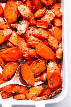 cooked carrots in a baking dish with a spoon