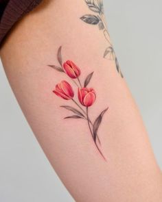 a woman's thigh with red flowers on it